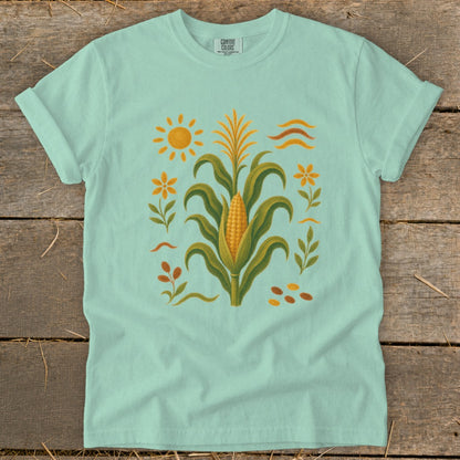 Mint green t-shirt with a corn stalk illustration and sun.