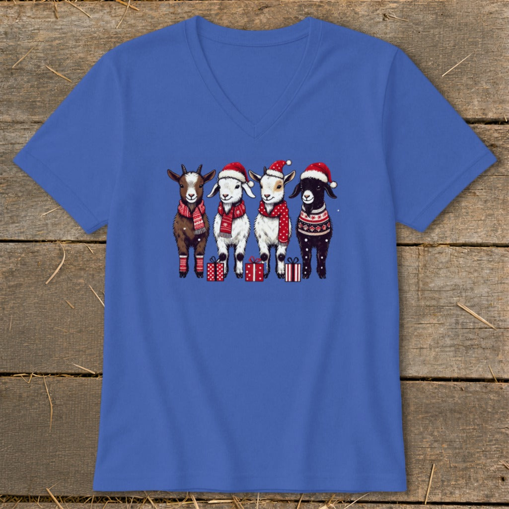 Four goats in Santa hats and scarves stand with presents.