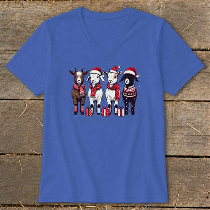 Four goats in Santa hats and scarves stand with presents.