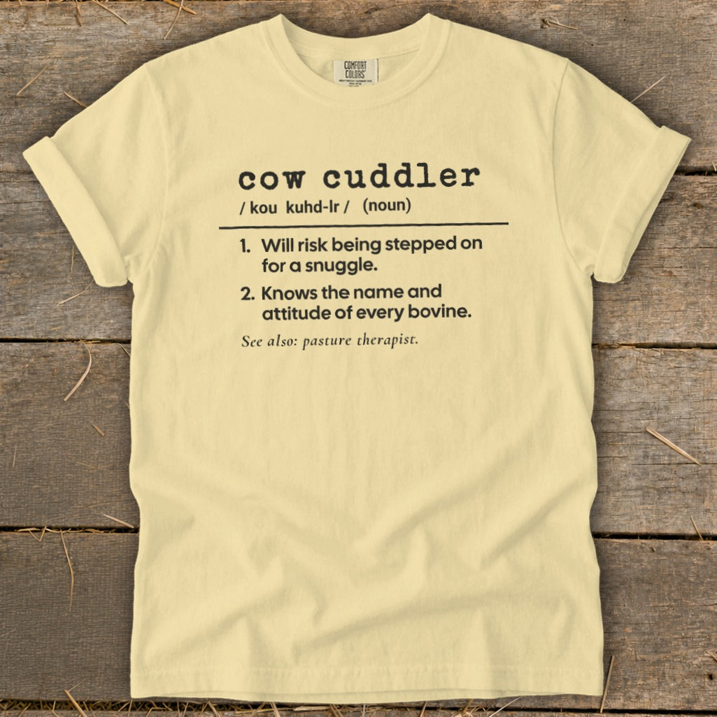Light yellow t-shirt with "cow cuddler" definition and "pasture therapist" reference.