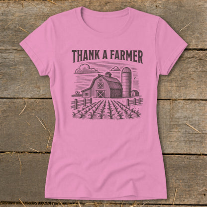 Pink t-shirt with a black ink drawing of a barn, silo, and cornfield.