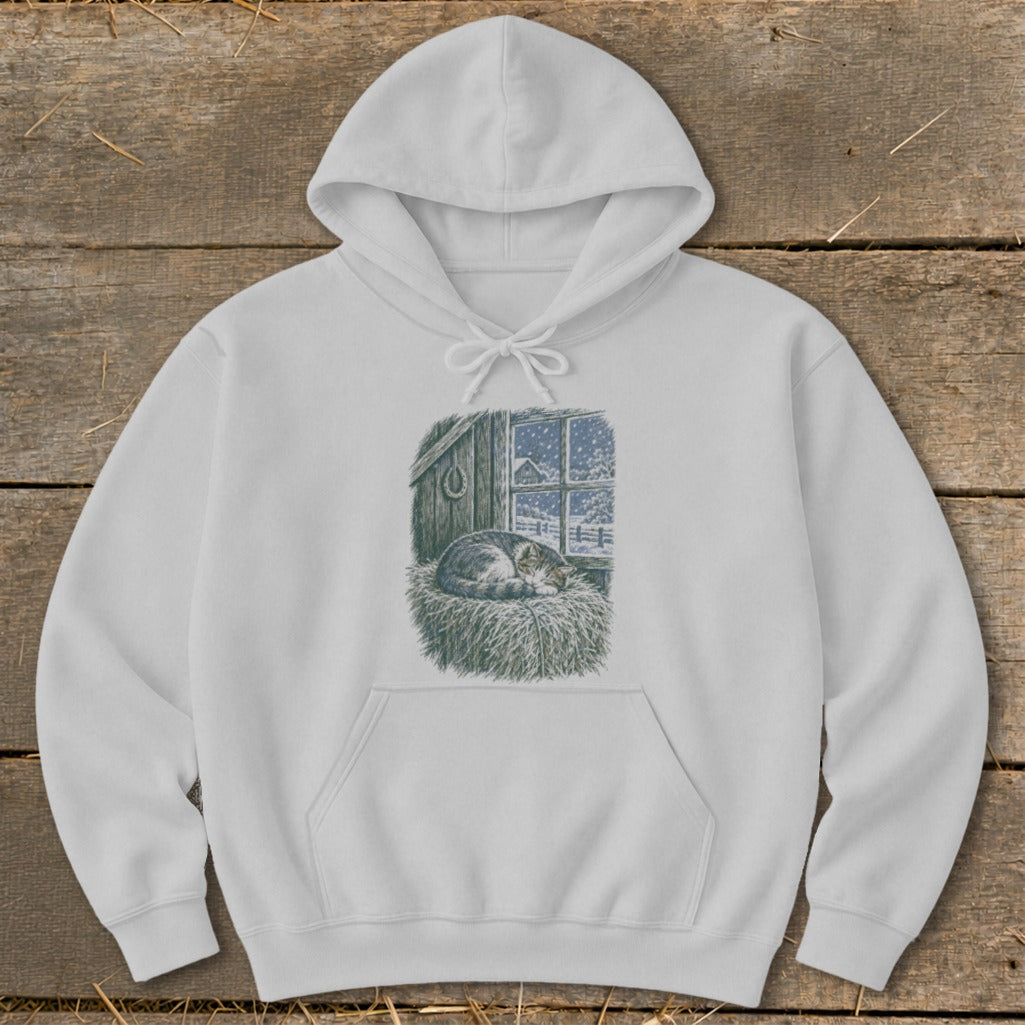 White hoodie with a graphic of a sleeping cat on hay in a barn window during a snowstorm.