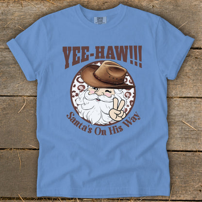 Blue t-shirt with Santa wearing a cowboy hat and saying "Yee-haw! Santa's On His Way".