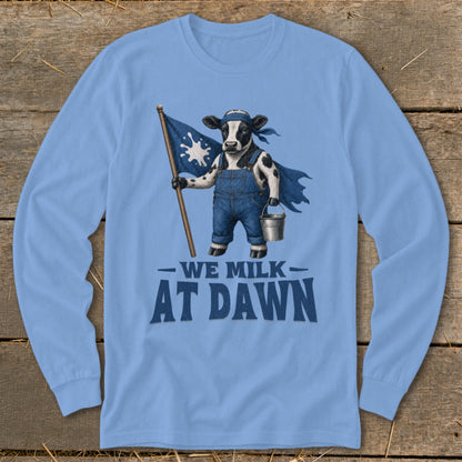 Cow wearing overalls and cape holding flag, "We Milk At Dawn" text.