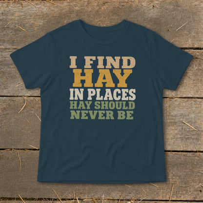 Dark blue t-shirt with text "I FIND HAY IN PLACES HAY SHOULD NEVER BE".