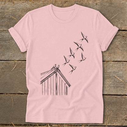Pink t-shirt featuring a black line drawing of swallows flying from a rooftop.
