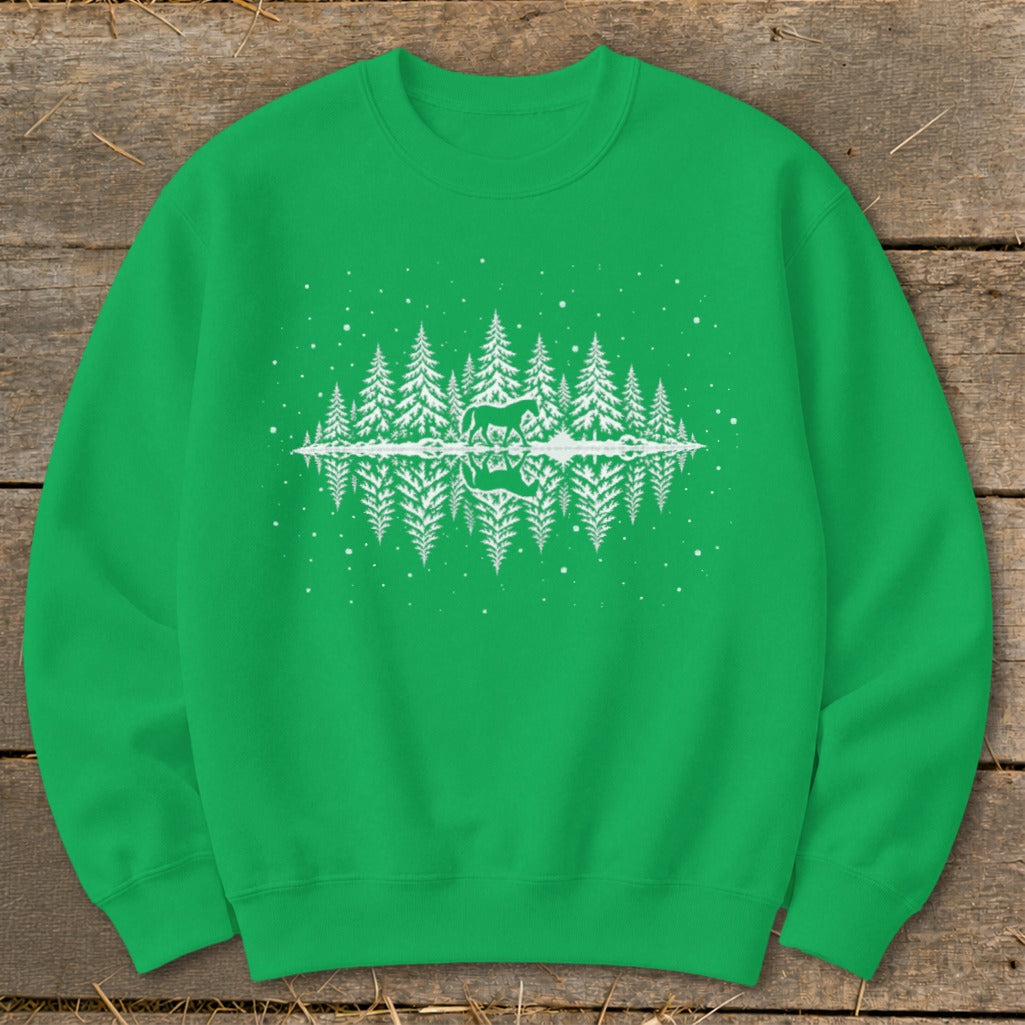 Green sweatshirt with white deer, forest, and snowflake reflection graphic.