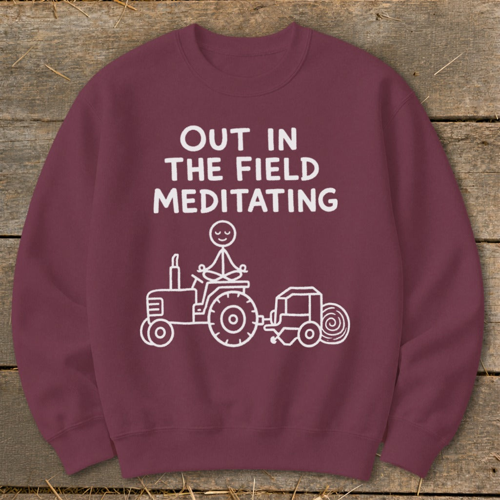 Maroon sweatshirt with white text and graphics of a meditating figure on a tractor.