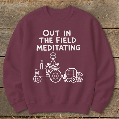 Maroon sweatshirt with white text and graphics of a meditating figure on a tractor.