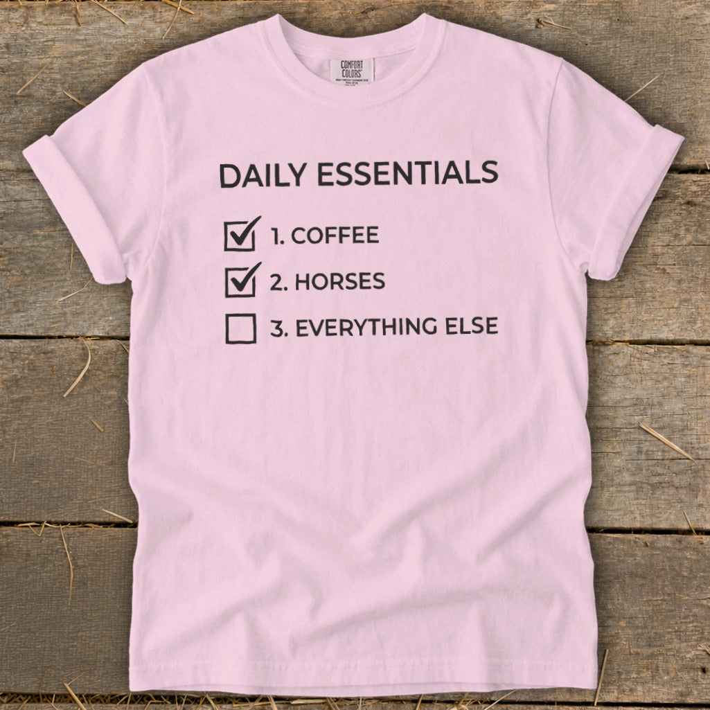 Pink t-shirt with "Daily Essentials" checklist: coffee, horses, everything else.