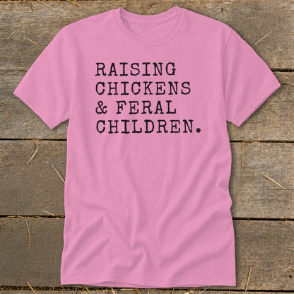 Pink t-shirt with black text reading "Raising Chickens & Feral Children."