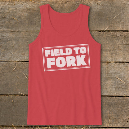 A red tank top featuring the white boxed text FIELD TO FORK laid on a rustic wooden background.