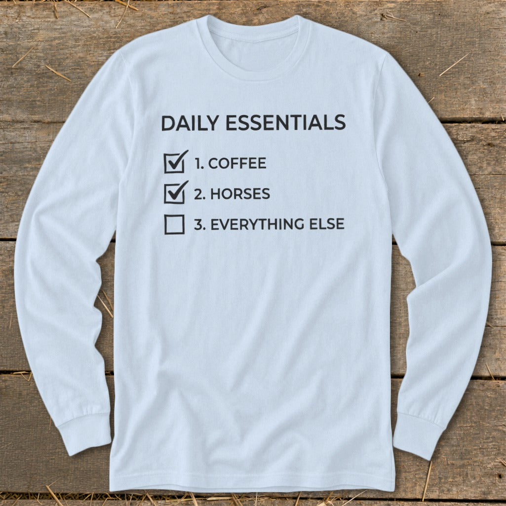 Light blue long-sleeve shirt with "Daily Essentials: 1. Coffee, 2. Horses, 3. Everything Else" text.