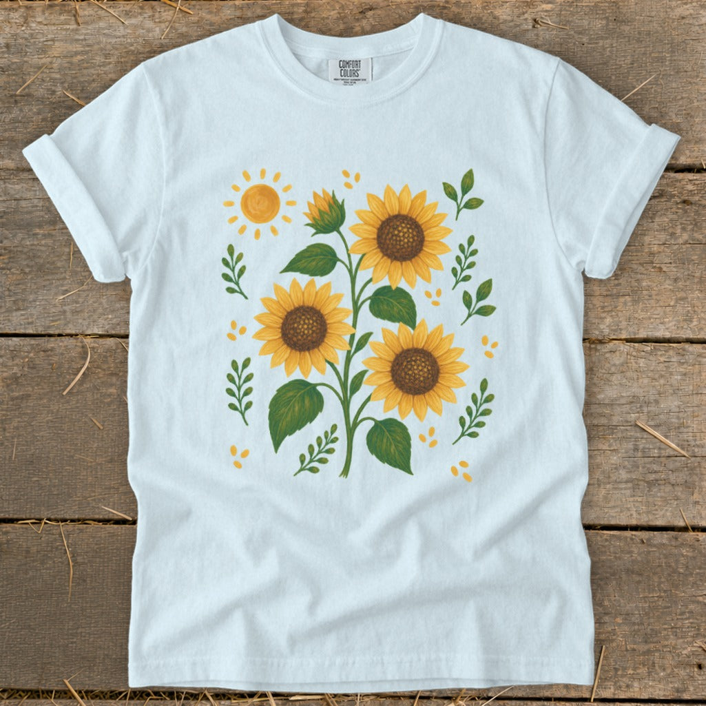White t-shirt with a design of sunflowers, leaves, and a sun.