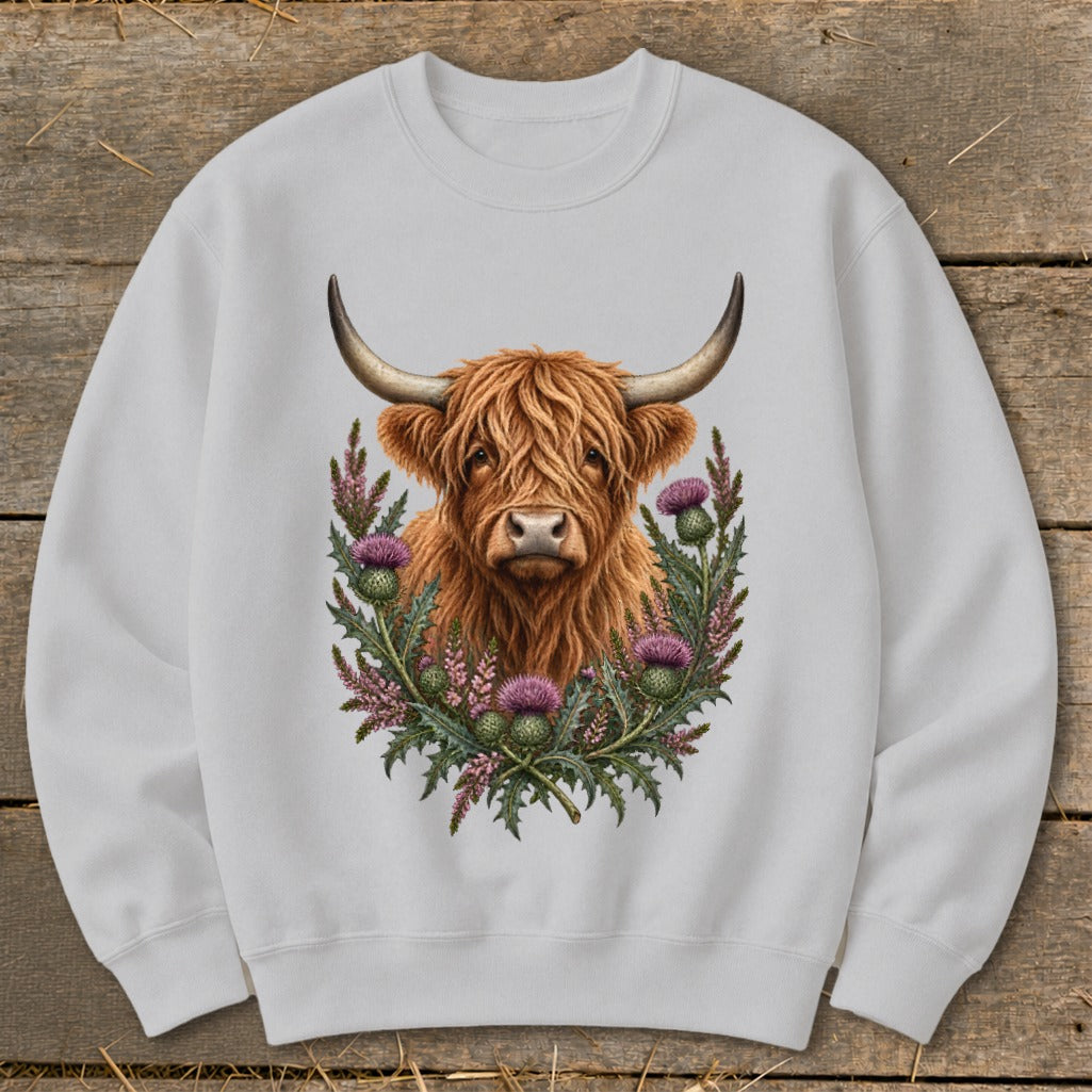 Light gray sweatshirt with a watercolor-style Highland cow head surrounded by thistles.