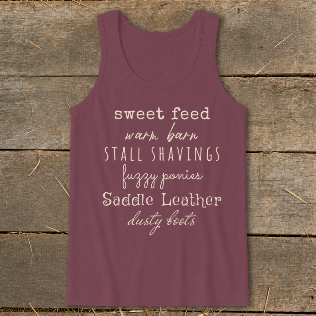 Maroon tank top with text: sweet feed, warm barn, stall shavings, fuzzy ponies, saddle leather, dusty boots.