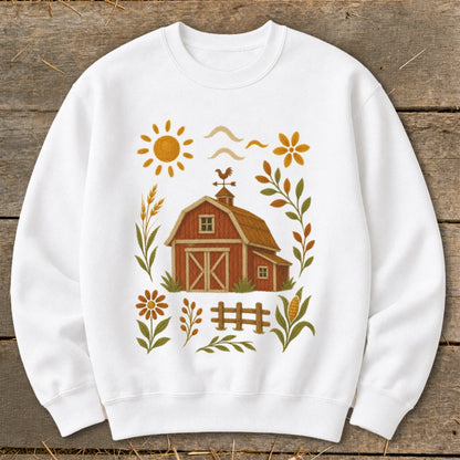 White sweatshirt with a barn, sun, flowers, and corn illustration.