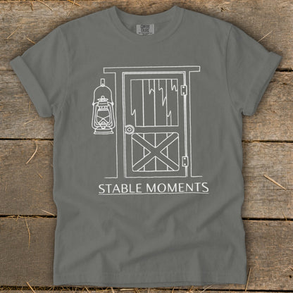 Gray t-shirt with white line art of barn door, lantern, and text "STABLE MOMENTS".