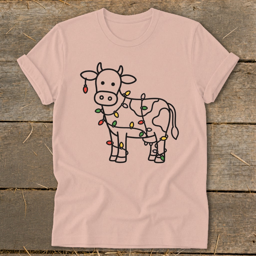 Line art cow wrapped in colorful Christmas lights on a pink t-shirt.