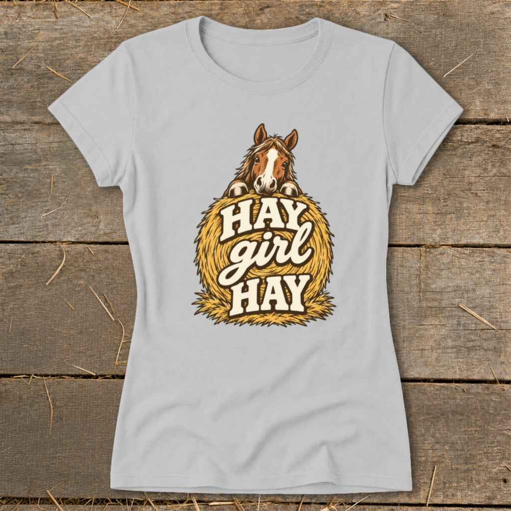 Light grey t-shirt with a horse peeking over a bale of hay, text reads "Hay girl Hay".