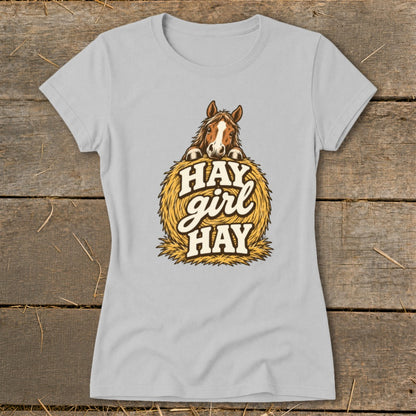 Light grey t-shirt with a horse peeking over a bale of hay, text reads "Hay girl Hay".