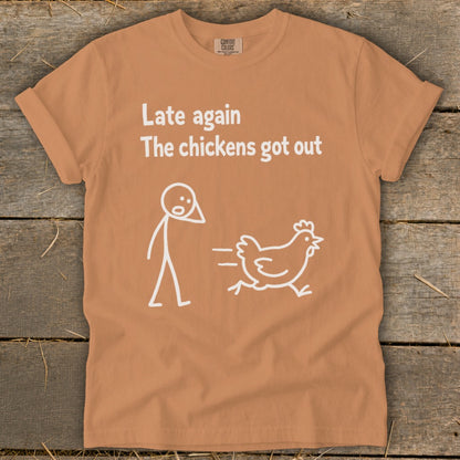 Orange t-shirt with white text "Late again the chickens got out" and a stick figure chasing a chicken.