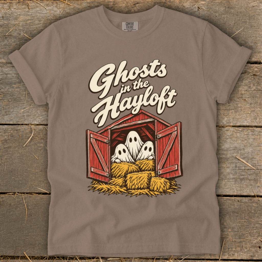 Three ghosts peek out from a red barn with hay bales, with "Ghosts in the Hayloft" text.