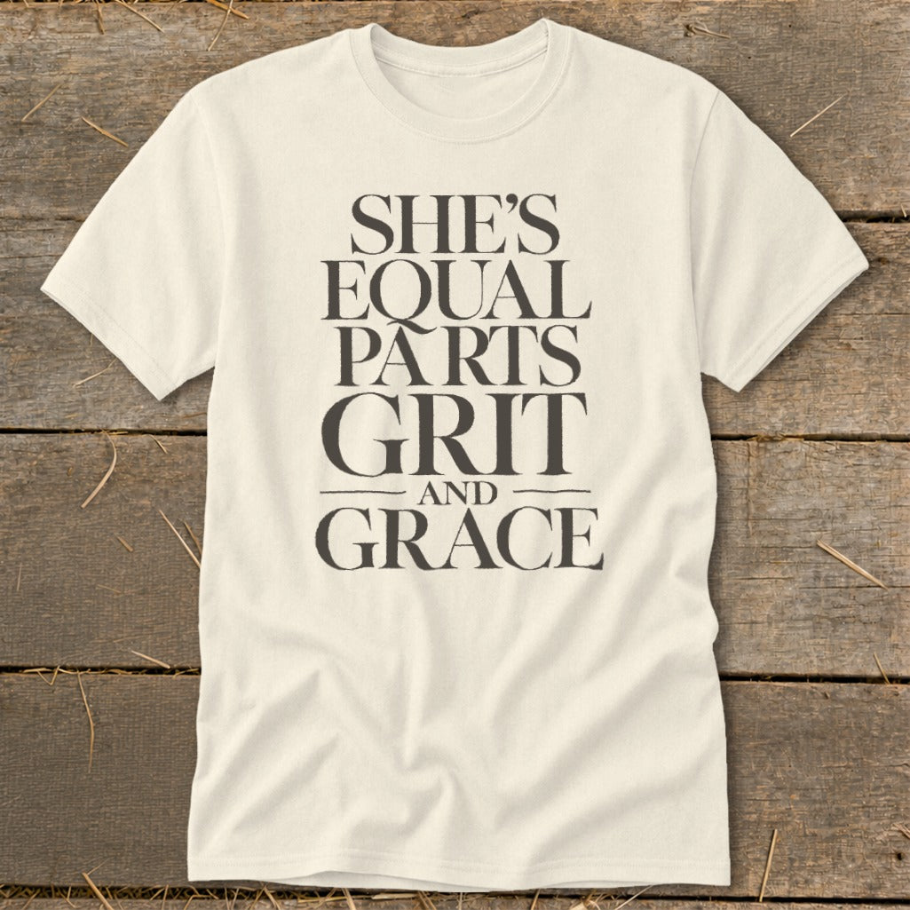 Cream t-shirt with black text that reads "SHE'S EQUAL PARTS GRIT AND GRACE".