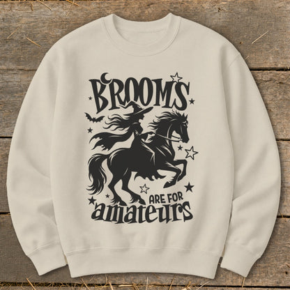 Black silhouette of a witch on a horse with text "BROOMS ARE FOR amateurs".