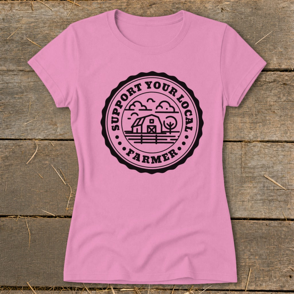 Pink t-shirt with black circular graphic featuring a barn, trees, and text.