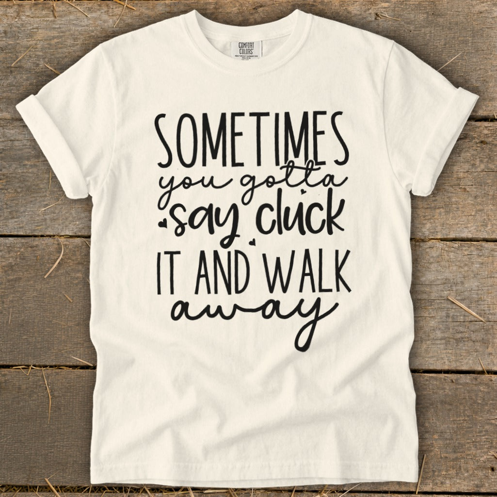 Cream t-shirt with black text reading "SOMETIMES you gotta say cluck IT AND WALK away".