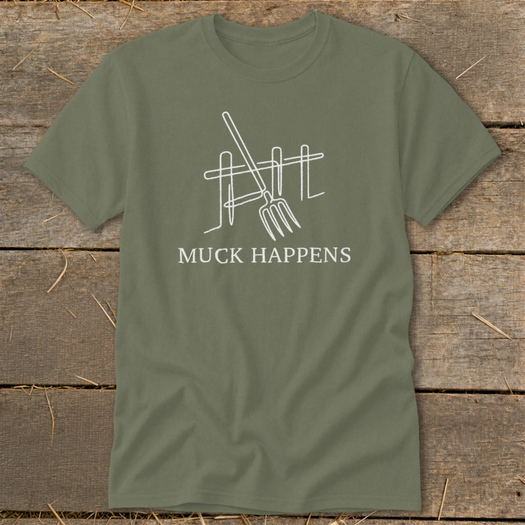 Olive green t-shirt with white graphic of a pitchfork and fence and text "MUCK HAPPENS".