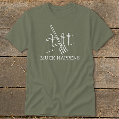 Olive green t-shirt with white graphic of a pitchfork and fence and text "MUCK HAPPENS".