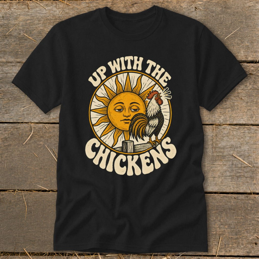 Black t-shirt featuring a graphic of a crowing rooster, a smiling sun, and the text Up With The Chickens.
