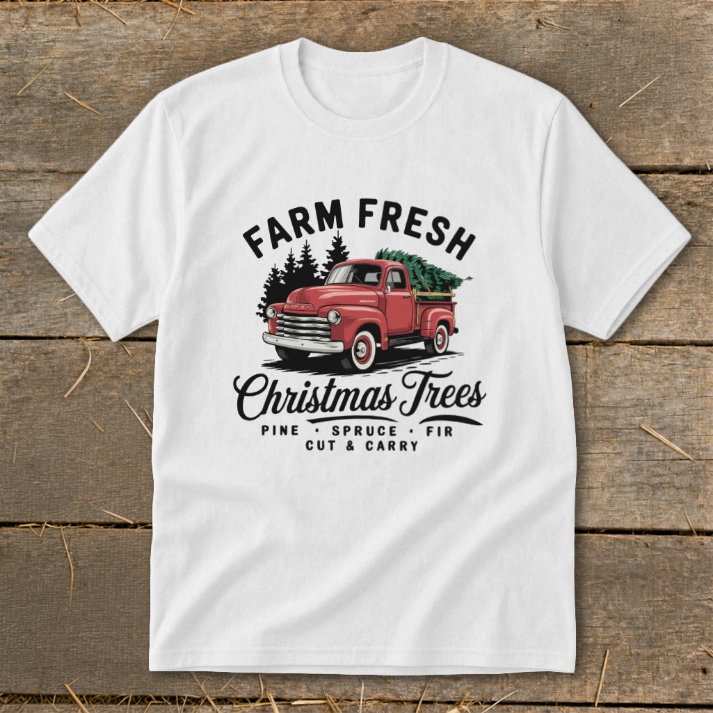 White t-shirt with a red truck carrying a Christmas tree and the text "Farm Fresh Christmas Trees."