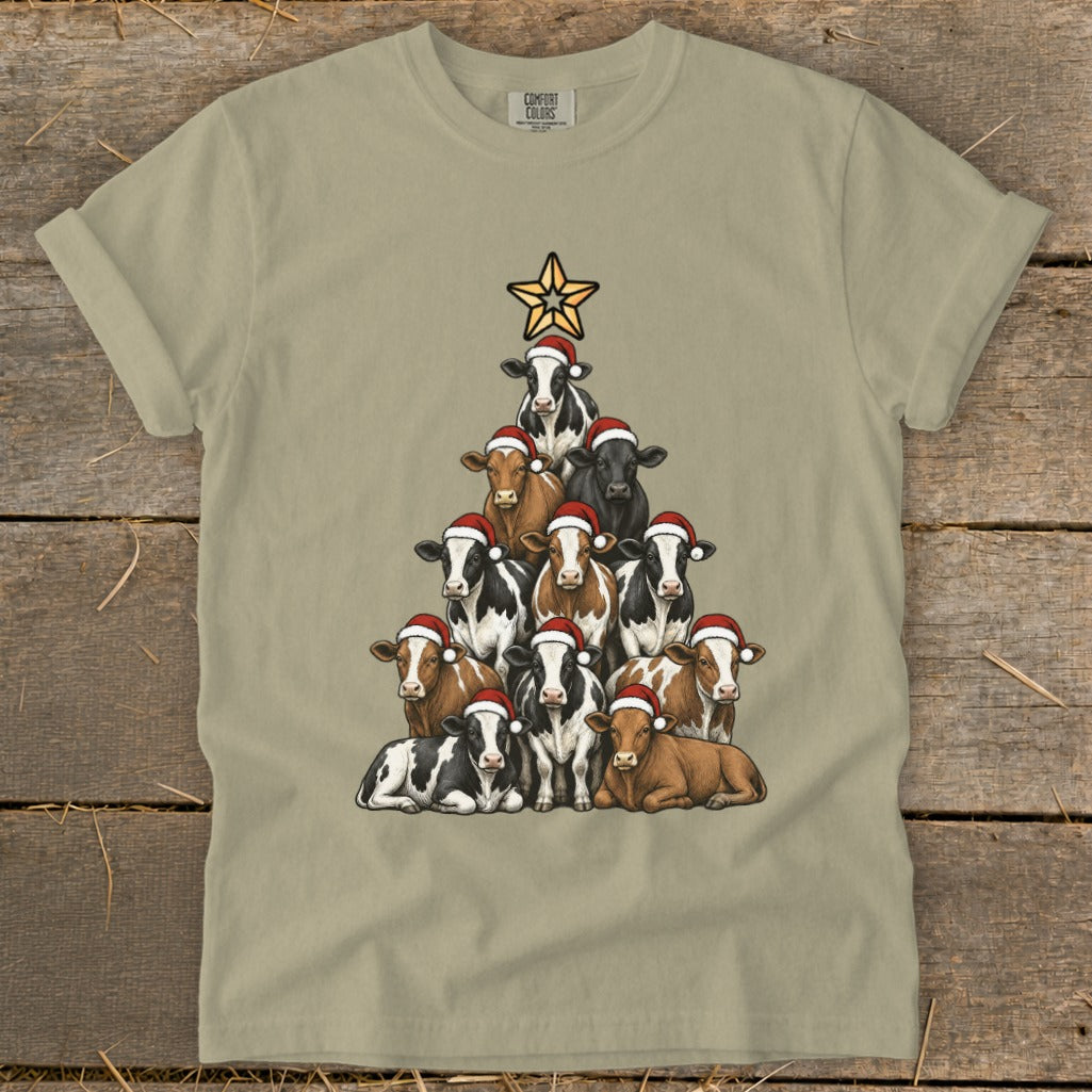 Cow Christmas tree design with Santa hats on a light tan t-shirt.