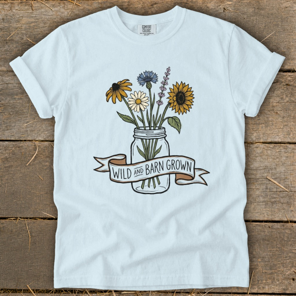 Light blue t-shirt with a mason jar of wildflowers and a banner reading "WILD and BARN GROWN".