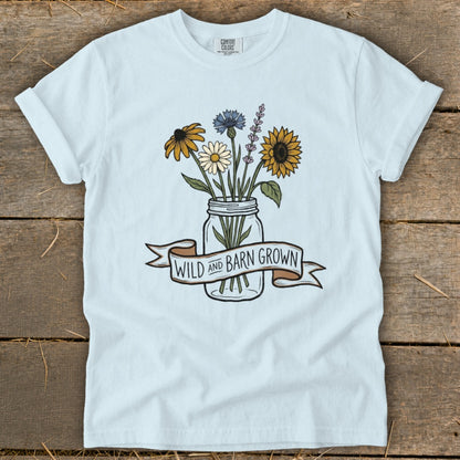 Light blue t-shirt with a mason jar of wildflowers and a banner reading "WILD and BARN GROWN".
