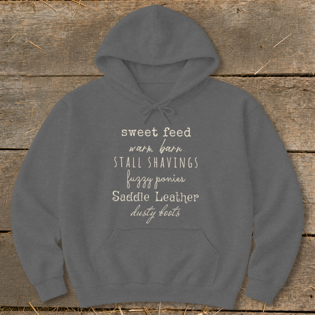 Dark grey hoodie with text "sweet feed, warm barn, stall shavings, fuzzy ponies, saddle leather, dusty boots".