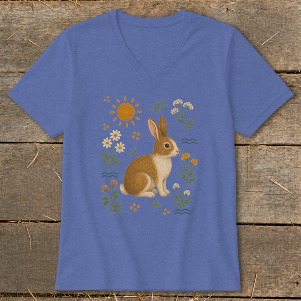 Blue v-neck t-shirt with a brown and white rabbit among flowers and sun.