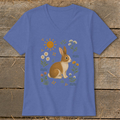 Blue v-neck t-shirt with a brown and white rabbit among flowers and sun.