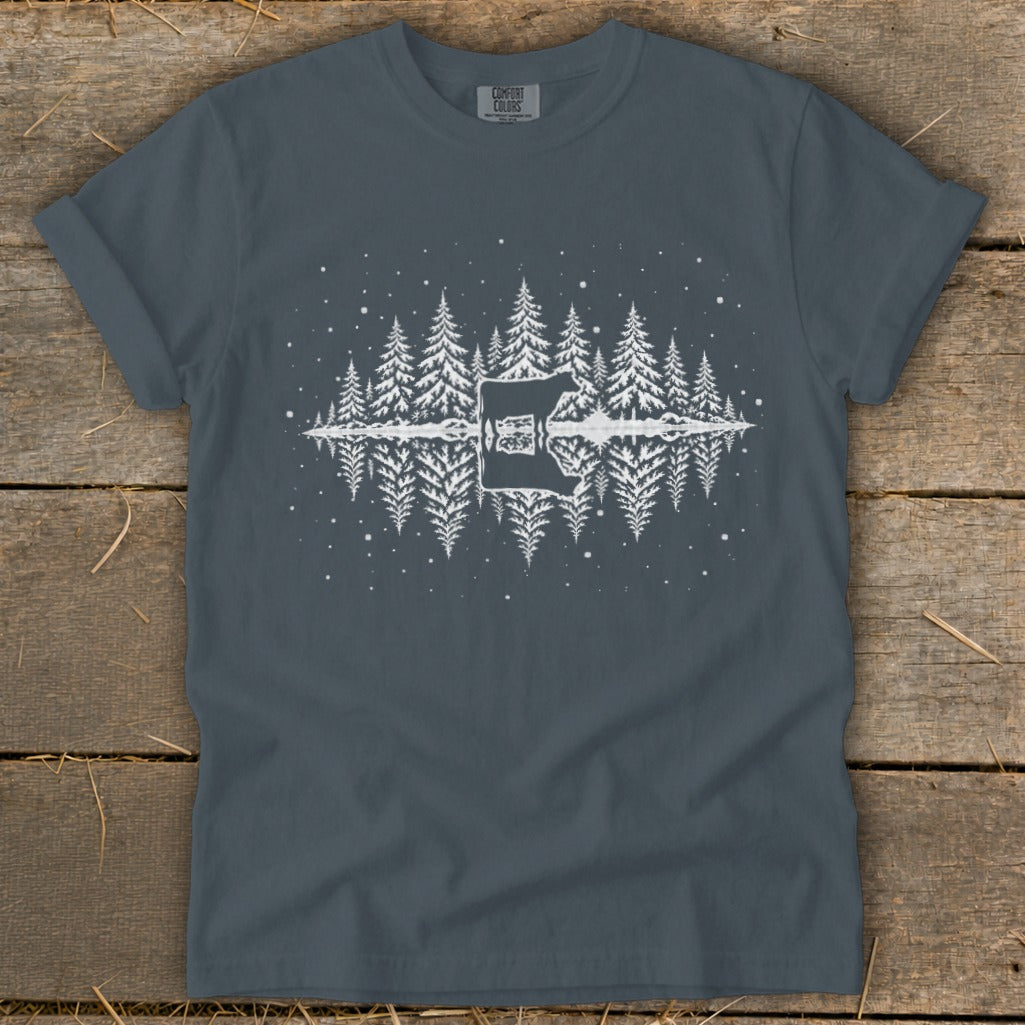 White graphic of a cow and pine trees reflected in water on a charcoal t-shirt.