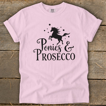 Pink t-shirt with black graphic of a horse and "Ponies & Prosecco" text.