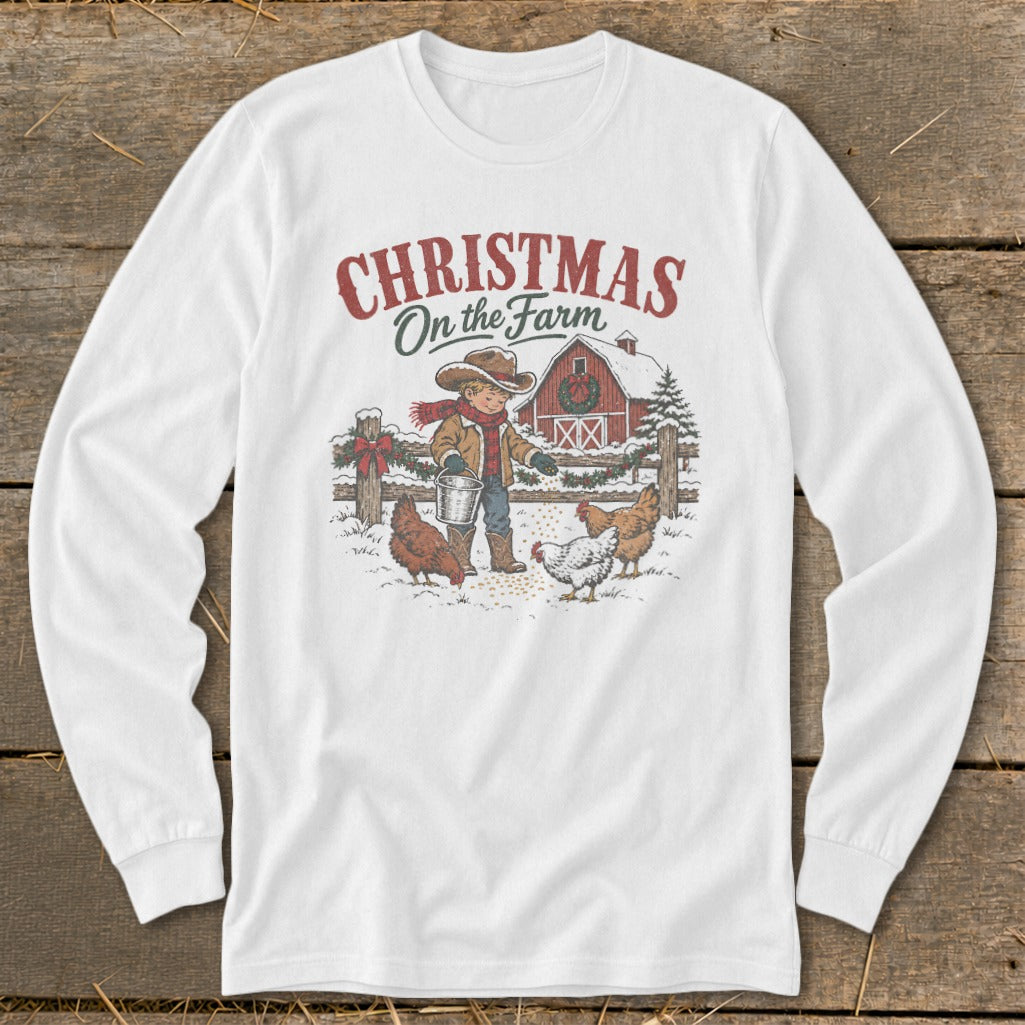 White long sleeve shirt with Christmas on the Farm graphic featuring a child feeding chickens.