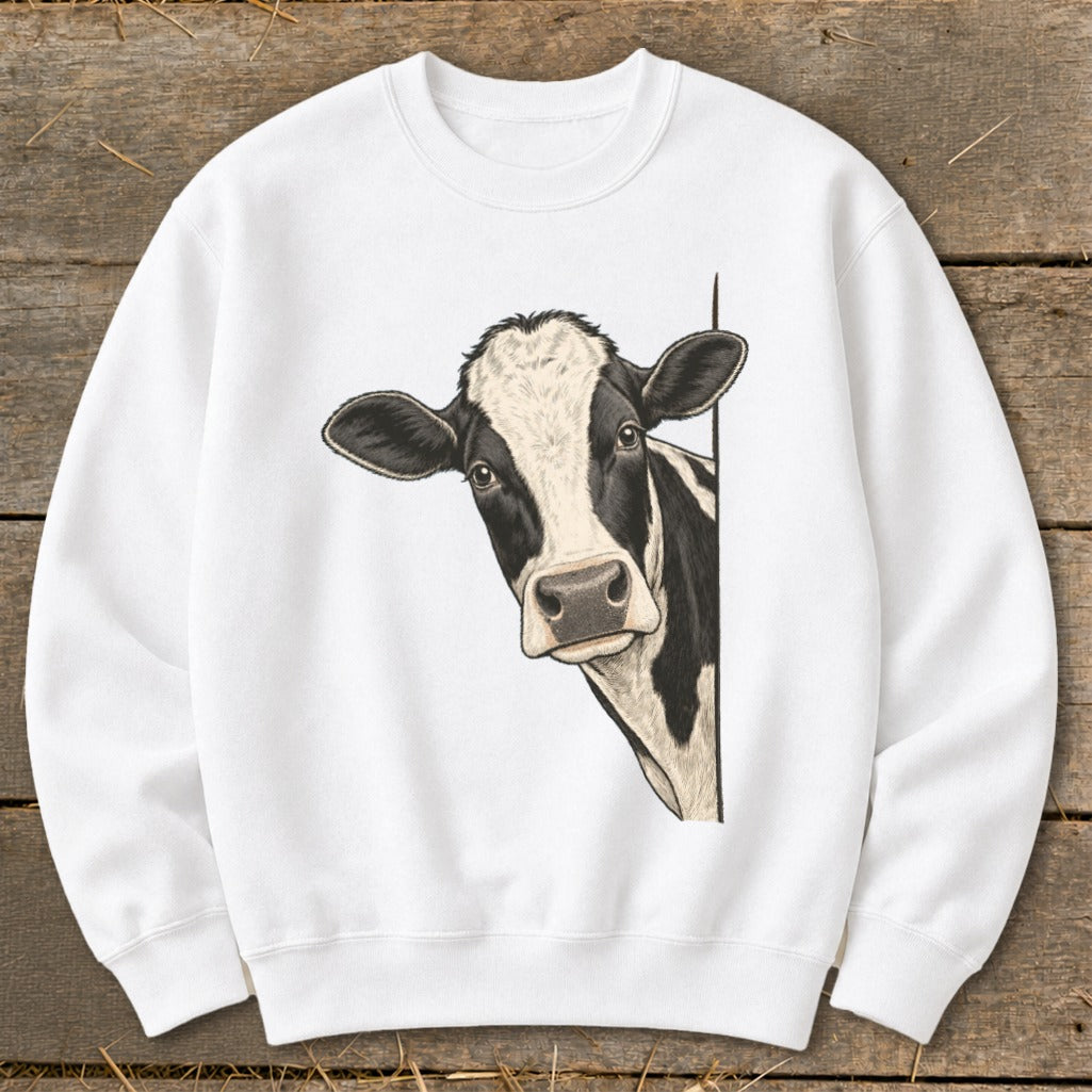 Black and white cow peeking from behind a white sweatshirt.