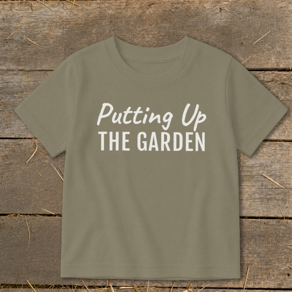 Olive green t-shirt with white text "Putting Up THE GARDEN"