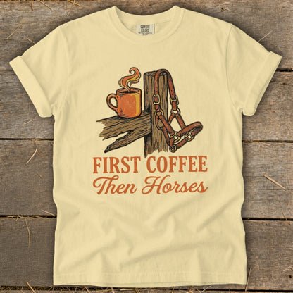 Light yellow t-shirt with rustic graphic of coffee cup and horse halter. "First Coffee Then Horses" text.