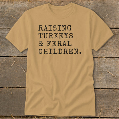 Tan t-shirt with black text reading "Raising Turkeys & Feral Children."