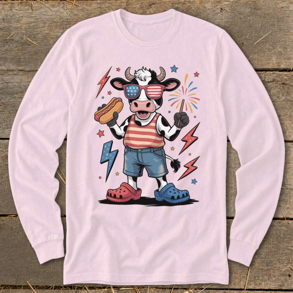 Cartoon cow in patriotic outfit holding a hot dog and sparkler, wearing sunglasses.