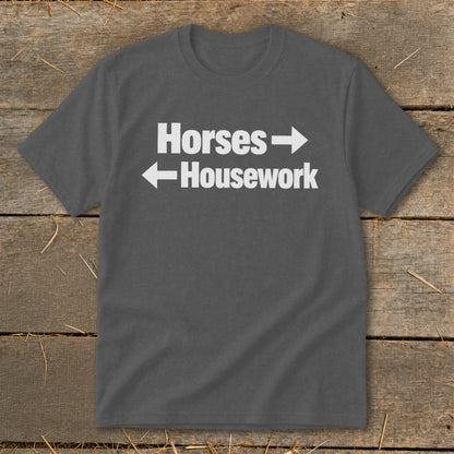 A dark gray t-shirt with white text reading Horses and Housework, separated by directional arrows.